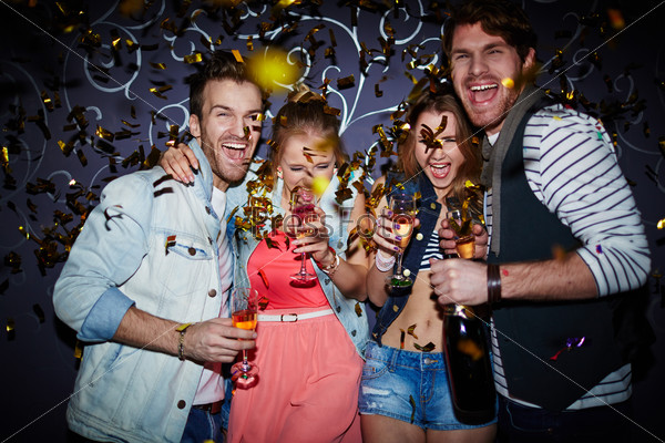 Ecstatic friends with champagne having fun at party