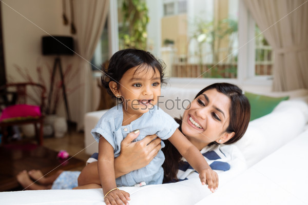 Young Indian mother and her little daughter having fun at home