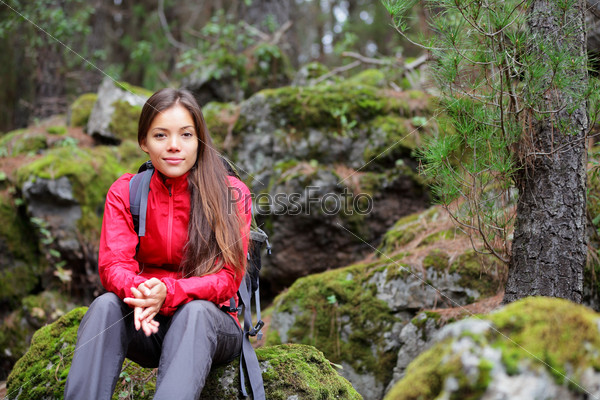 Hiking. Woman hiker in forest taking a rest sitting down. Beautiful young Asian Caucasian model. From La Caldera, Aguamansa, Orotava, Tenerife, Canary Islands, Spain. Winter.