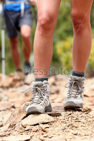 Hiker. Hiking shoes close up outdoors during hike - female shoes. Hikers in the background