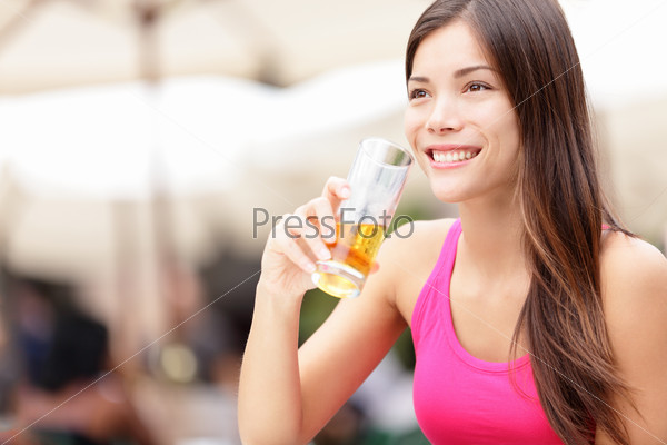 Woman on cafe drinking drink smiling happy looking at copy space. Asian young woman drinking alcohol, rum, in Havana, Cuba.