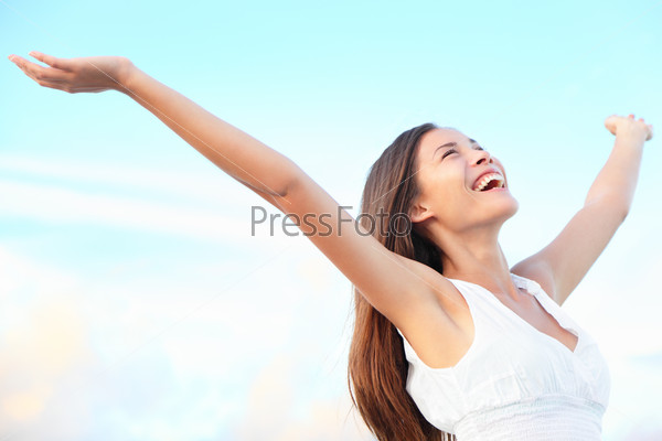 Happiness bliss freedom concept. Woman happy smiling joyful with arms up dancing on beach in summer during holidays travel. Beautiful young cheerful mixed race Asian Chinese / Caucasian female model.