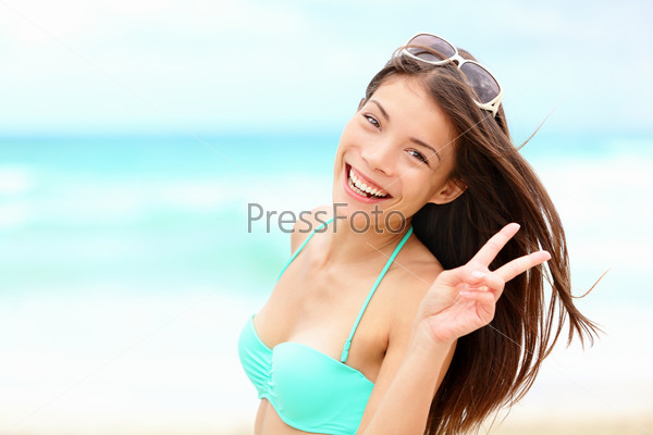 Happy beach vacation woman joyful smiling on beautiful tropical beach during summer holidays. Fresh mixed race Caucasian / Chinese Asian bikini model.