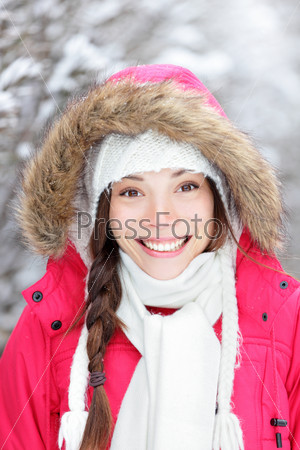 Portrait of winter woman smiling happy and cheerful outside in snow winter forest. Beautiful mixed-race Asian Chinese / Caucasian female model.