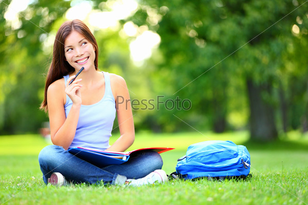 Student thinking looking in park Joyful happy asian girl student sitting writing and reading outside on university campus park. Mixed race Chinese Asian / Caucasian female student looking away