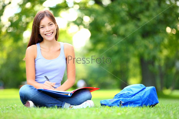 Student studying in park Joyful happy asian girl student\
sitting writing and reading outside on university campus or park\
Mixed race Chinese Asian Caucasian female student woman looking at\
camera