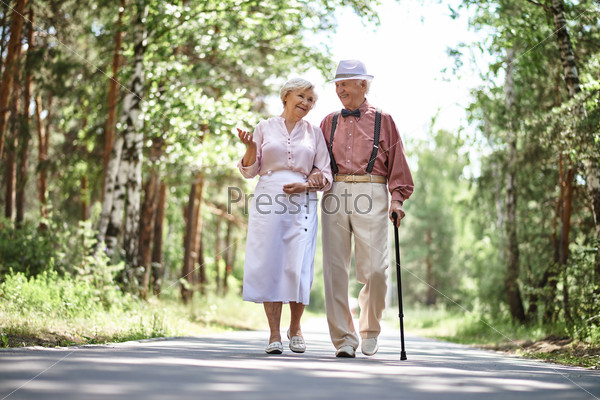 Portrait of happy senior couple walking in park