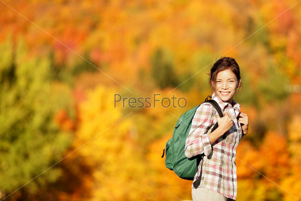 Hiking woman in Fall forest. Female hiker looking around in forest in autumn colors. Beautiful young woman on hike.