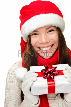 Christmas santa woman holding gift. Smiling happy cute young woman wearing santa hat showing christmas present isolated on white background. Joyful mixed race Asian Caucasian santa girl.