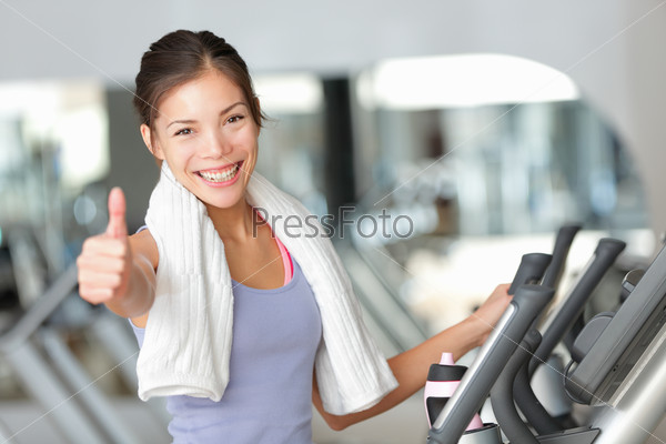 Happy fitness woman thumbs up in gym during exercise training on moonwalker treadmill.
