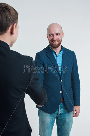 a man in a business suit greeted with a man on a white background