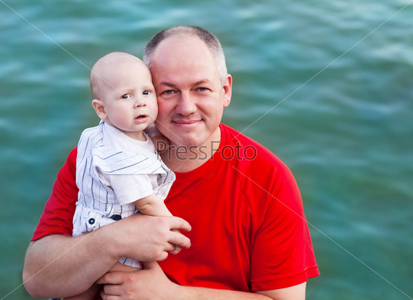 Middle age father and his little son walking along the river
