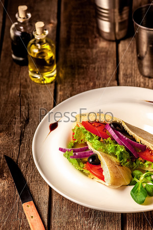 Vegetarian Pita Bread Sandwich on the white plate on wooden table