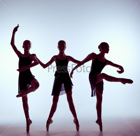 Composition from silhouettes of three young dancers in ballet poses on a gray background.  The outline shooting - silhouettes of girls.