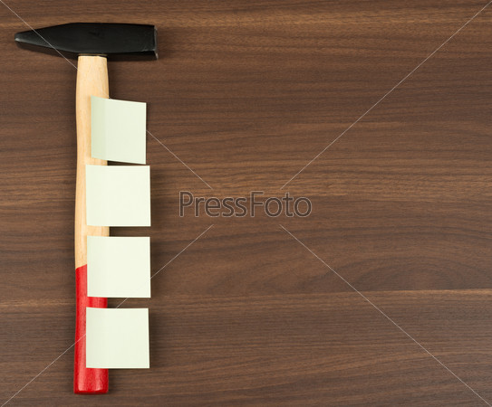Stickers on hammer lying on brown wooden table, top view