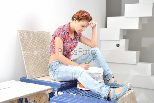 Young beautiful woman sits and thinks of repair