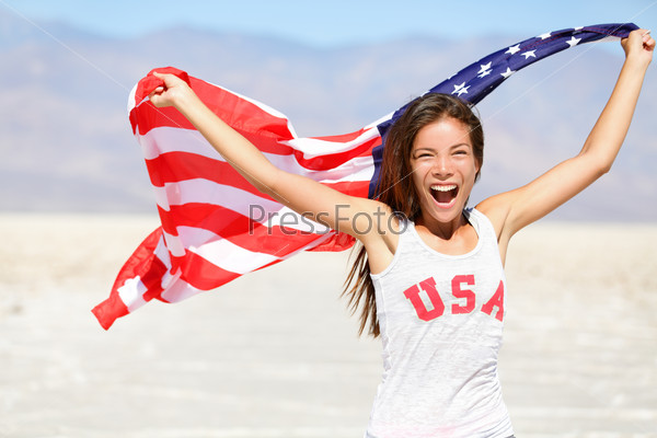 American flag - woman USA sport athlete winner cheering waving US flag Stars and Stripes outdoor running in nature. Beautiful cheering happy young multicultural girl joyful and excited.
