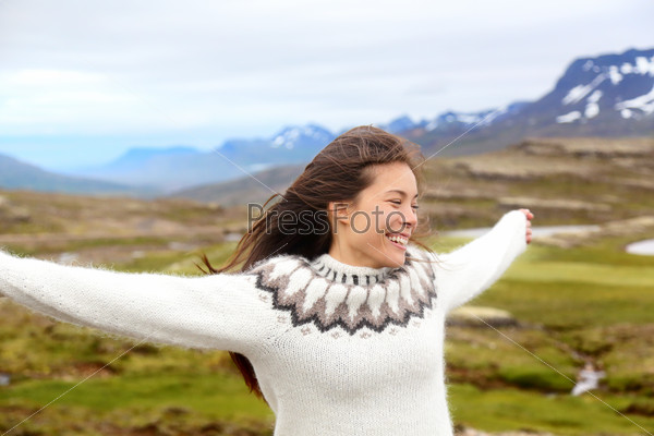 Happy free woman on Iceland in Icelandic sweater. Portrait of girl happy smiling outdoors in nature wearing Icelandic sweater. Pretty Asian Caucasian multiracial female model