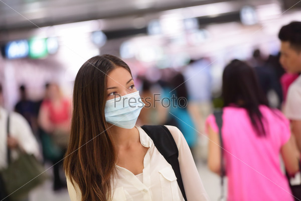 Люди носят защитные маски в аэропорту