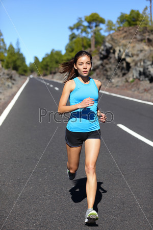 Running woman - female runner jogging outdoors on road training for marathon run as part of healthy lifestyle outdoor workout in summer. Mixed race Asian Caucasian model.