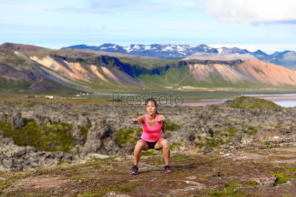 Girl exercising outdoors doing jump squat
