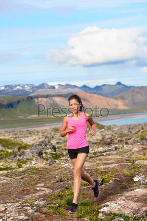 Athlete runner woman running in nature. Female fitness girl cross country trail running in amazing nature landscape outside. Image from Iceland.