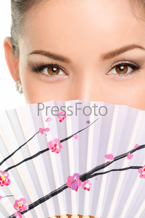 Asian eyes woman. Eye makeup asian look with paper fan. Beauty portrait of mixed race Asian / Caucasian female model on white background. Close up on eyes.