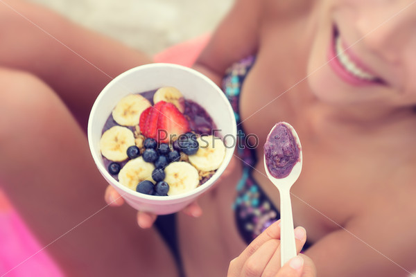 Девушка ест здоровую пищу на пляже