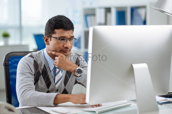 Unhappy Indian programmer looking at computer screen