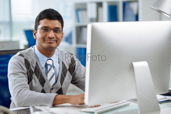 Smiling software developer working on computer