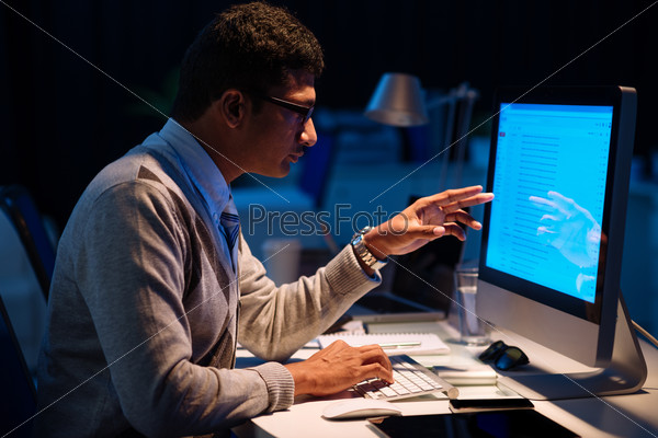 Businessman analyzing information of his computer screen, he is working overtime