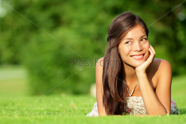 Asian woman lying in grass