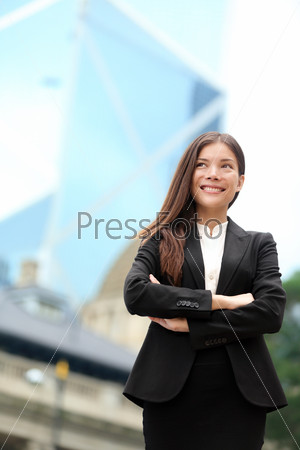 Asian business woman confident outdoor in Hong Kong standing proud in suit cross-armed in business district. Young mixed race female Chinese Asian / Caucasian female professional in central Hong Kong.