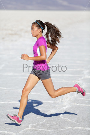 Running woman - runner sprinting on trail run in desert nature landscape. Female sport fitness athlete in high speed sprint in amazing desert landscape outside. Multiracial fit sports model sprinter.