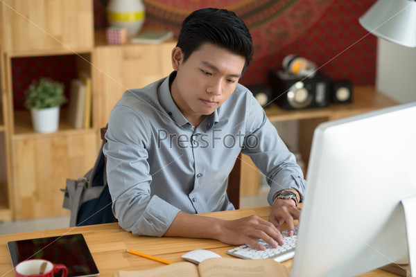 Concentrated university student doing homework at home