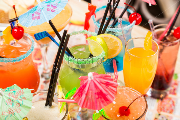different freshness cocktails with ice in glasses with drinking straw and umbrellas