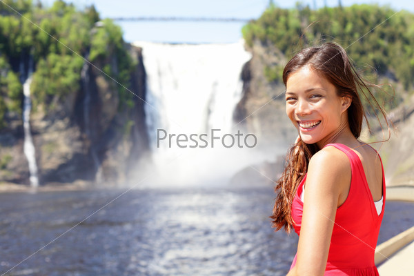 Chute montmorency falls quebec and woman tourist smiling happy in red summer dress looking at