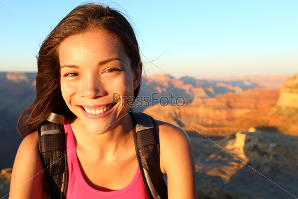 Hiker woman smiling natural canidid in happy outdoor portrait. Aspirational lifestyle image of hiking young multiracial female hiker in Grand Canyon, South Rim, Arizona, USA.