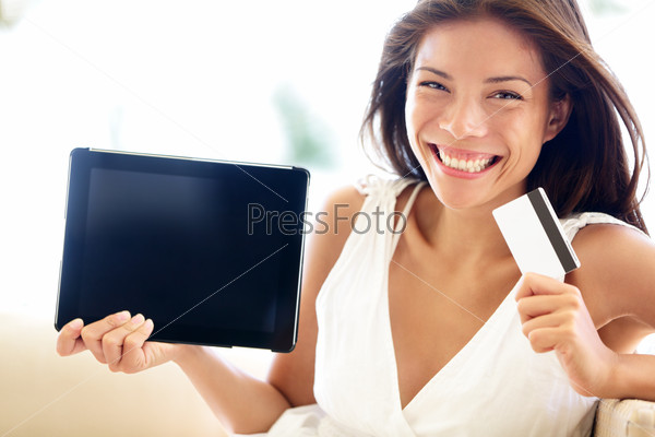 Internet shopping woman online with tablet pc and credit card. Internet shopper buying things on the internet showing blank tablet pc computer as sign. Multicultural Asian Caucasian model happy