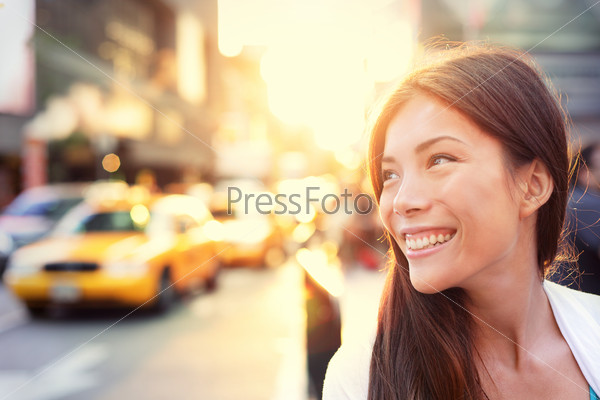 Asian Woman Vivacious In New York City With A Beautiful Beaming Smile Backlit By The Warm Glow Of The Sun Shining Down A Busy Street With Taxicabs In Downtown Manhattan, New York City.