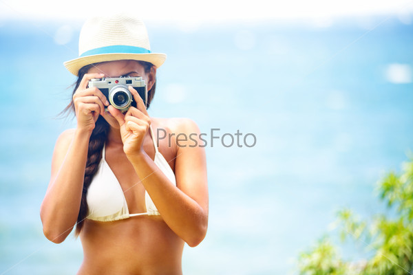 Summer beach woman holding camera taking picture