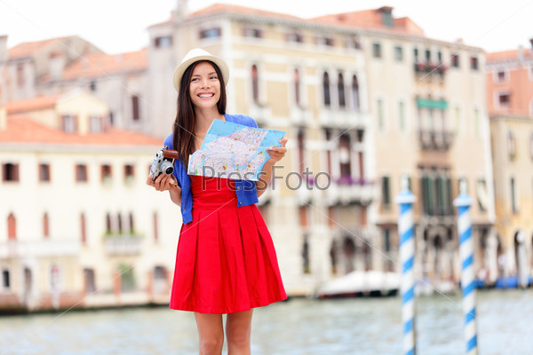 Travel tourist woman with camera and map in Venice, Italy. Asian girl on vacation smiling happy by Grand Canal. Mixed race Asian Caucasian girl having fun traveling outdoors during holidays in Europe.