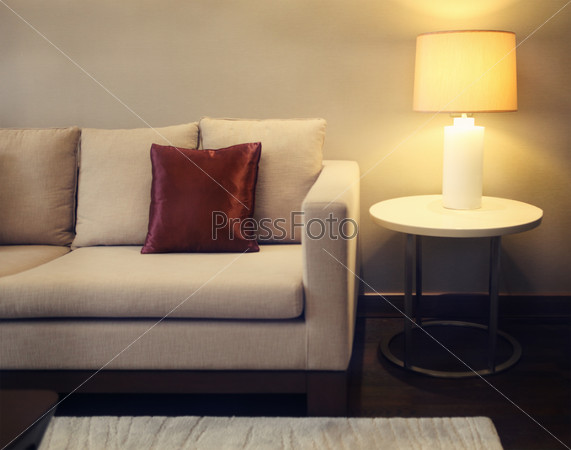 Cozy beautiful living room with beige sofa and lamp with copy space. Toned image.