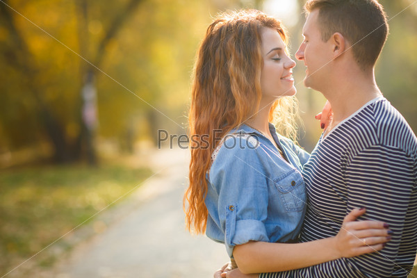 Cheerful couple having fun on summer vacation. Portrait of a happy couple laughing at camera. Young couple in the countryside in autumn.