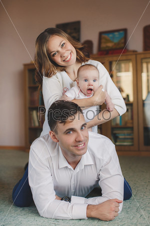 Happy young family with a small child in her arms.