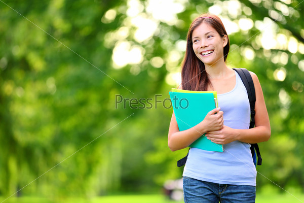 Student girl outdoor in park smiling happy going back to school. Asian female college or university student. Mixed race Asian / Caucasian young woman model wearing school bag holding books.