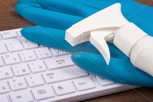 Airbrush with rubber gloves and keyboard on brown wooden table, side view, stock photo