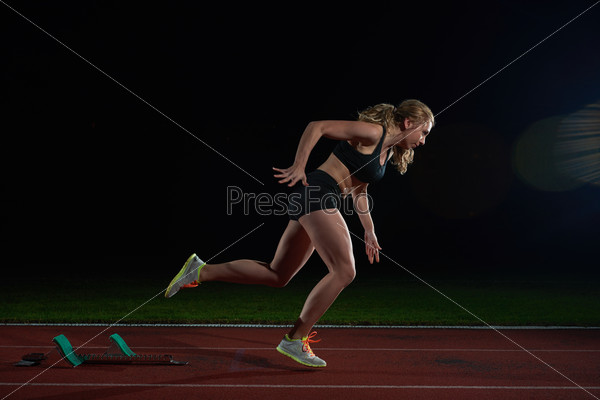 woman sprinter leaving starting blocks