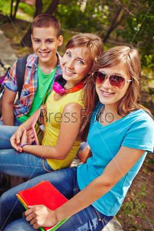 Friendly teens resting in park after lessons