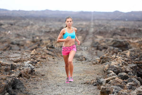 Runner woman triathlete trail running cross country running outdoors on volcano. Female athlete jogging training for marathon run outside in beautiful landscape on Big Island, Hawaii, USA.
